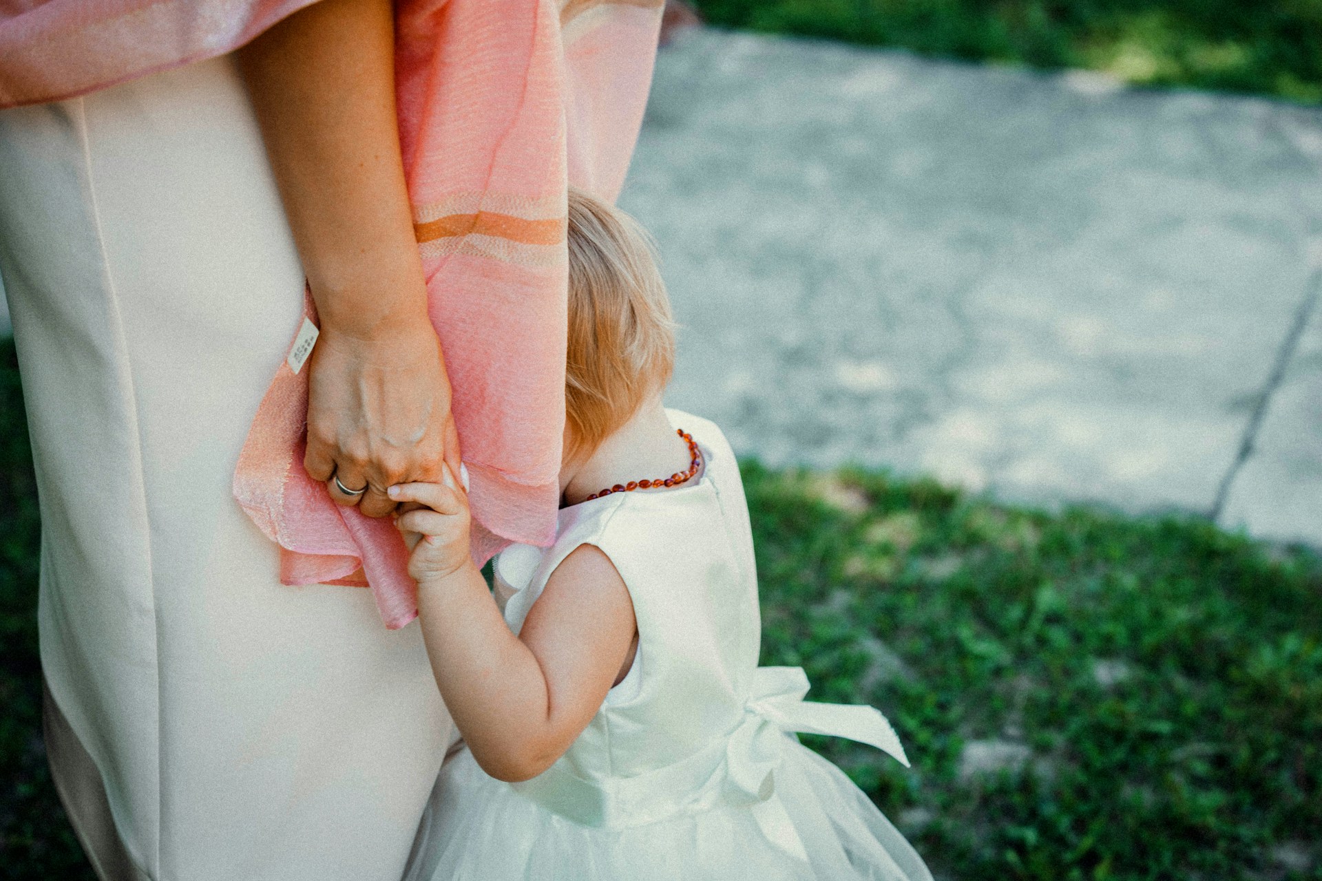 a little kid feels ashamed and hides in her moms lap