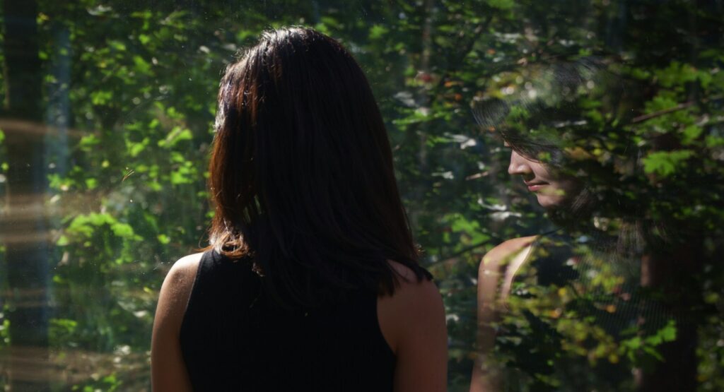 reflection of a woman in the mirror, she's ruminating about life